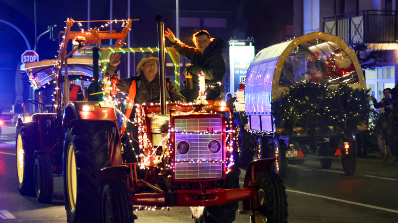 Weihnachtlich geschmückte Trecker begeistern die großen und kleinen Gäste am Straßenrand