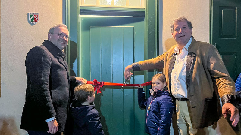 Bürgermeister Erik Lierenfeld und Stefan Gödderz (re.), Vorsitzender des BSV Delhoven, öffnen mit zwei Kindern der Tannenbusch-Schule die Tür zur sanierten Alten Schule