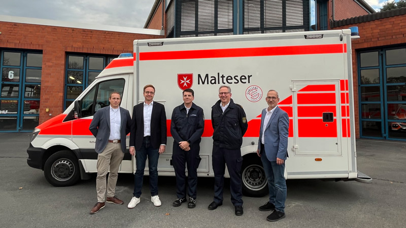 Tim Gladis und  Oliver Röhrs (Malteser) sowie Achim Mittnacht und  Norbert Buchkremer (Feuerwehr) mit Dr. Torsten Spillmann (Stadt Dormagen) vor dem Krankentransportwagen der Malteser (v. li.)