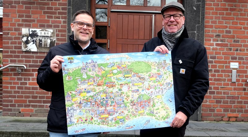 Marco Gillrath (links) und Frank Picht halten die Neuauflage des Dormagener Wimmelbildes in den Händen