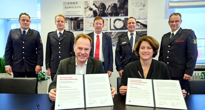 Bei der Unterzeichnung, von links: Brandrat Stefan Holtkamp, Feuerwehrchef David von der Lieth, Dr. Stephan Keller, Stadtdirektor und Feuerwehrdezernent Burkhard Hintzsche, André Klöckener (Leiter Kreisleitstelle), Katharina Reinhold, Michael Wolff (Kreisbrandmeister)