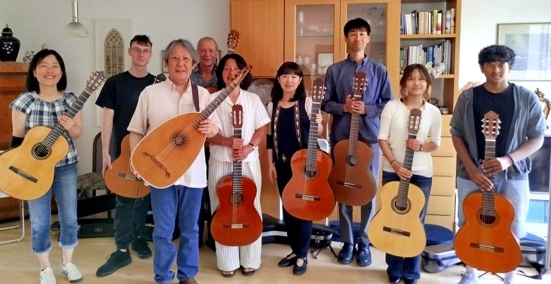 Die Schülerinnen und Schüler mit Gitarrenlehrer Yoshimasa Yoshida und Gastgeber Dieter Frankenstein im Hintergrund